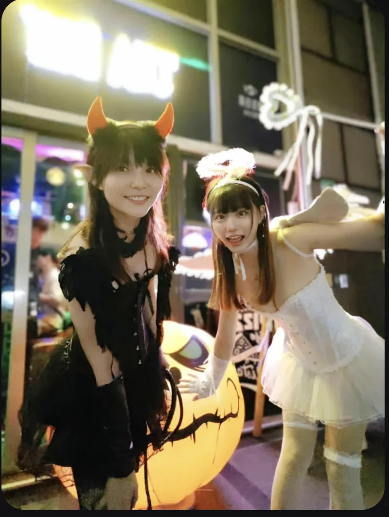 Two guests in Halloween costumes posing outside TEA BAR