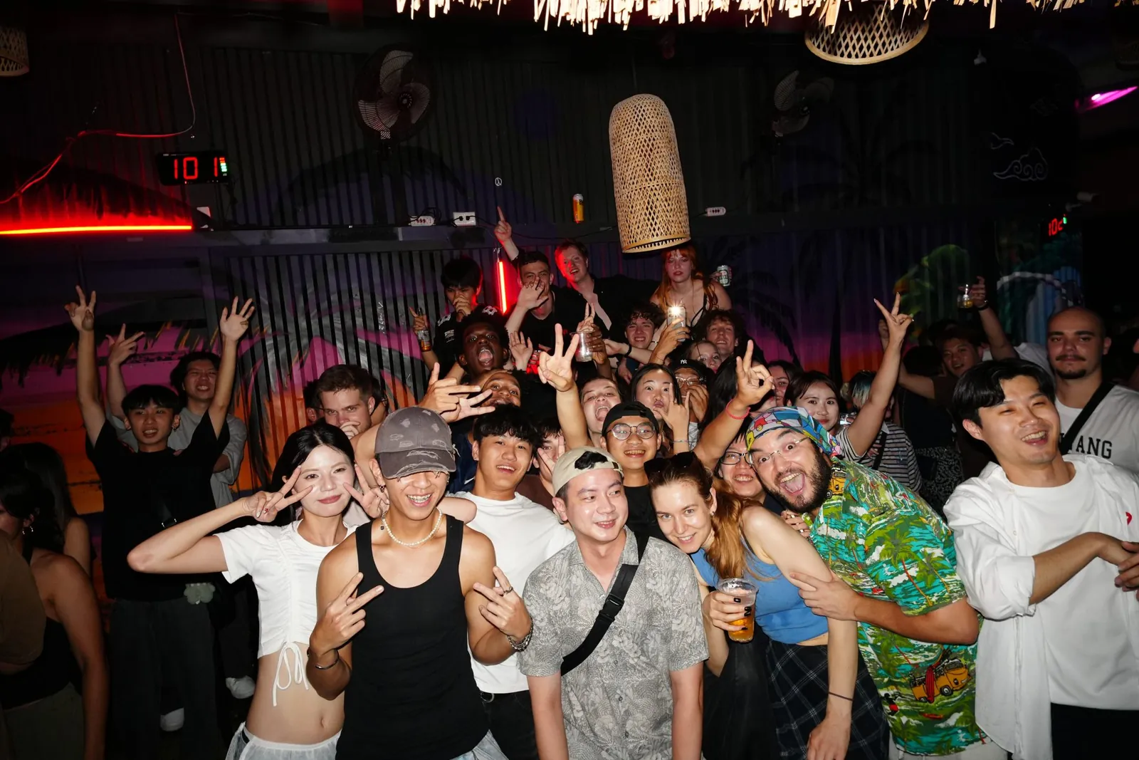 A large group raising their hands together at a Taipei bar