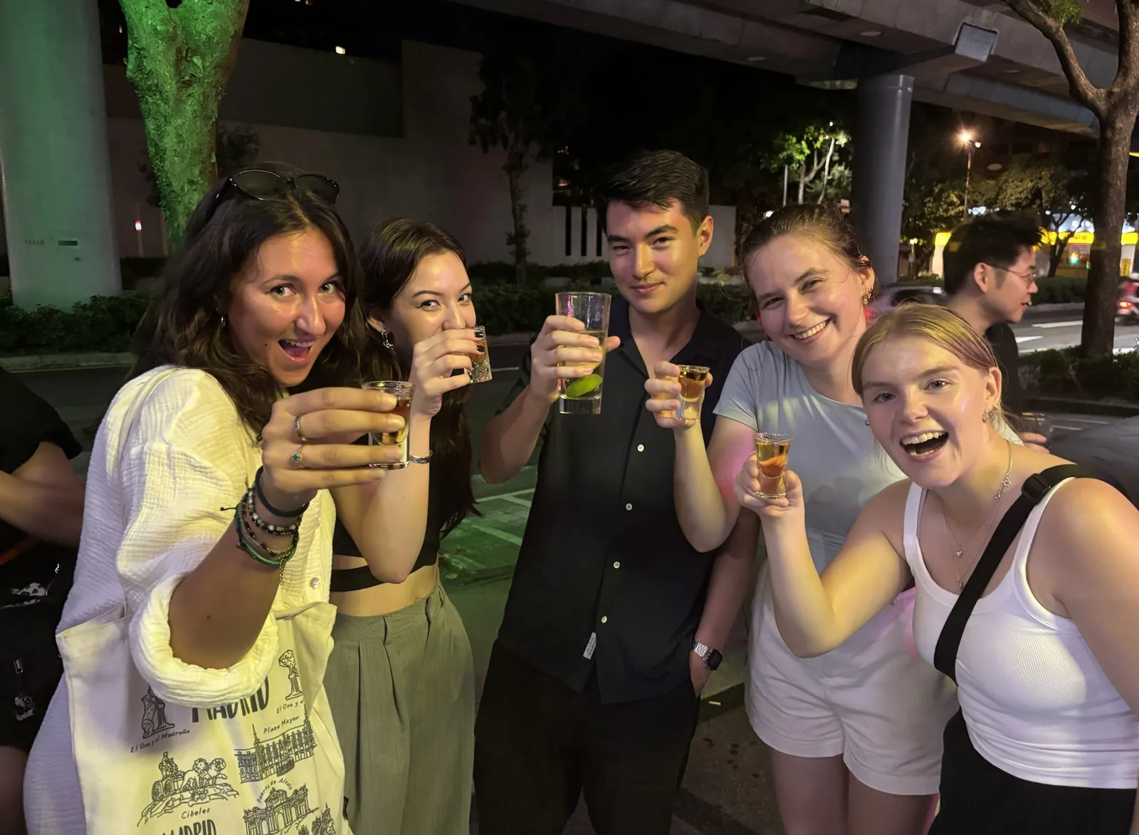 Five guests raising their drinks together outdoors