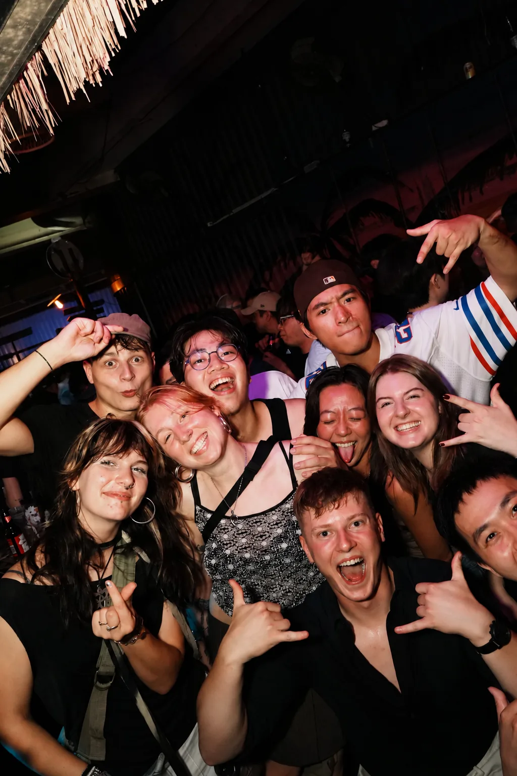 A group of guests raising their hands at a nightlife gathering