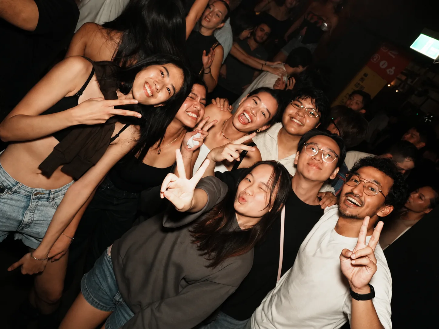 Guests leaning together for a group photo at a bar